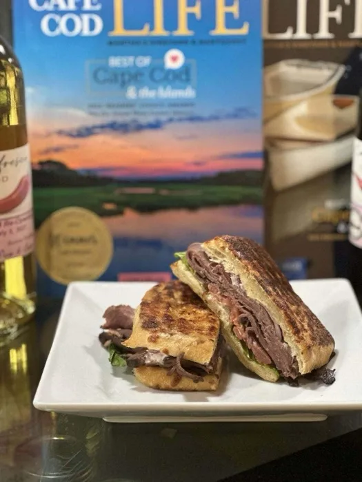 Roast beef panini sliced in half on a plate